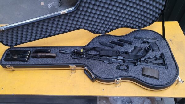 Fuzil T4 em um estojo de violão